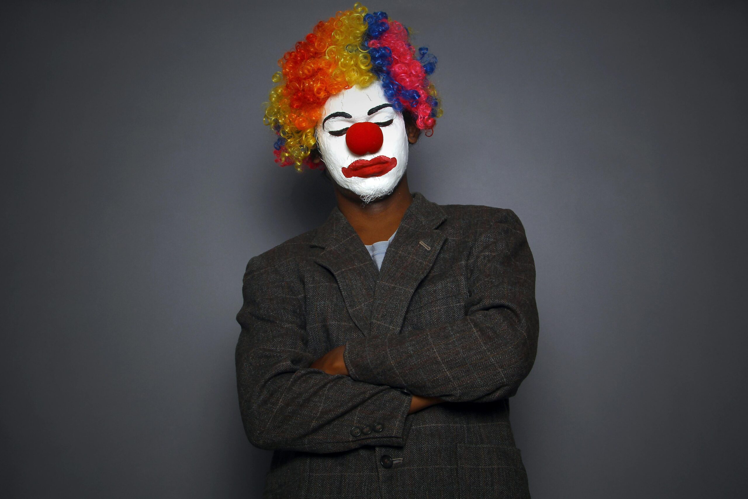 Vibrant clown portrait with face paint and colorful wig, perfect for circus or arts themes.